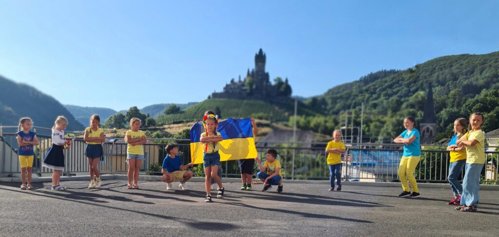Auf dem Foto sieht man viele tanzende Kinder.