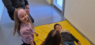 Stabile Seitenlage Kinder versuchen sich gegenseitig in die stabile Seitenlage zu bekommen