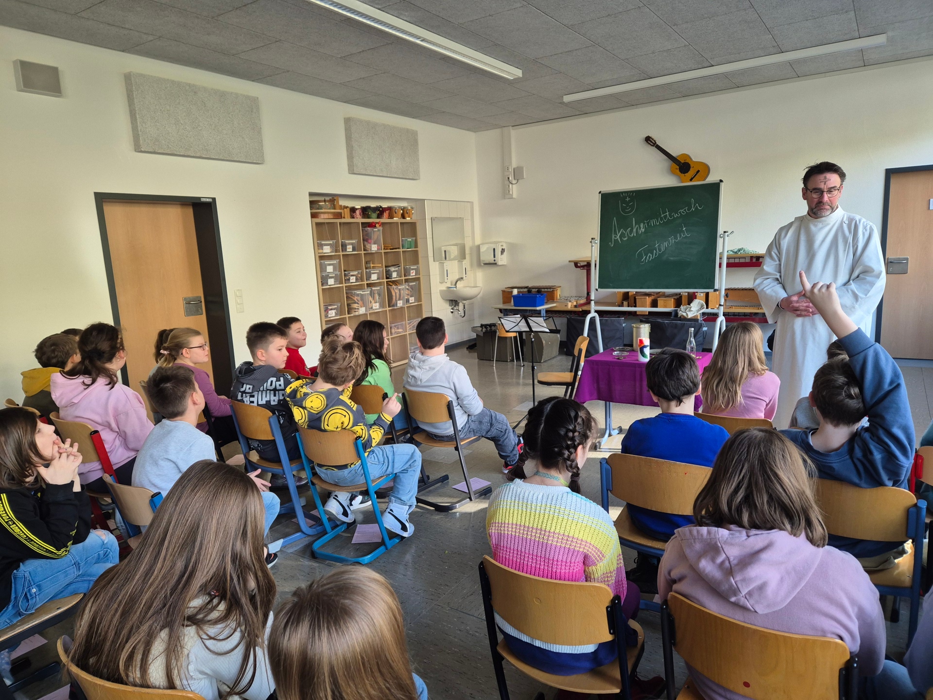 Die Kinder hören, was Herr Berenz erzählt.