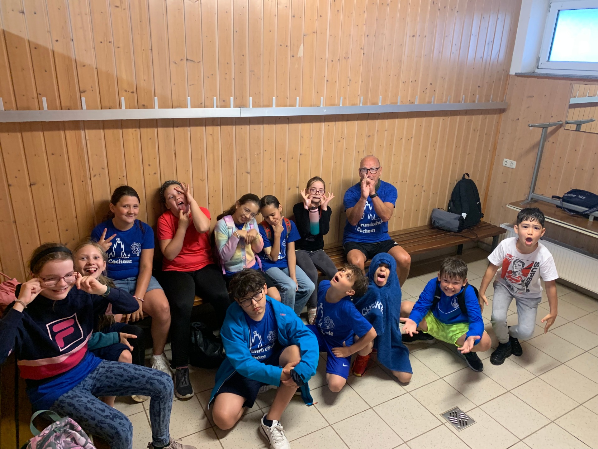 Alle 14 Kinder machen mit Herrn Bauer ein Gruppenfoto.