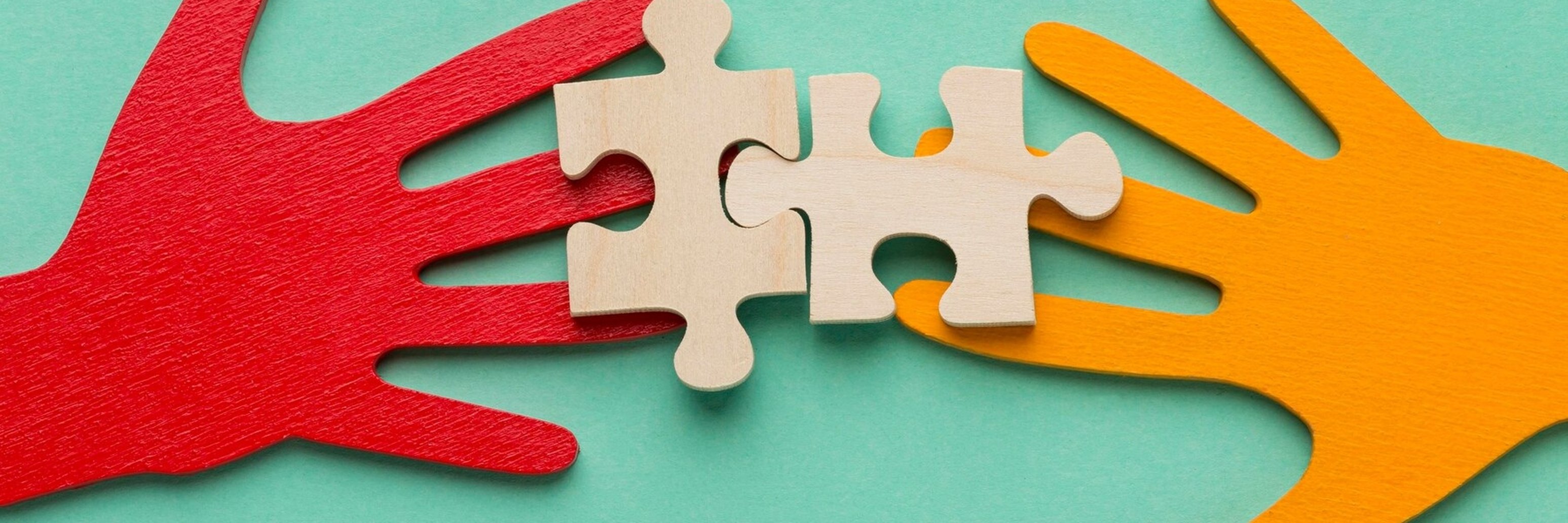 Hände zwei bunte Hände mit zwei Puzzleteilen