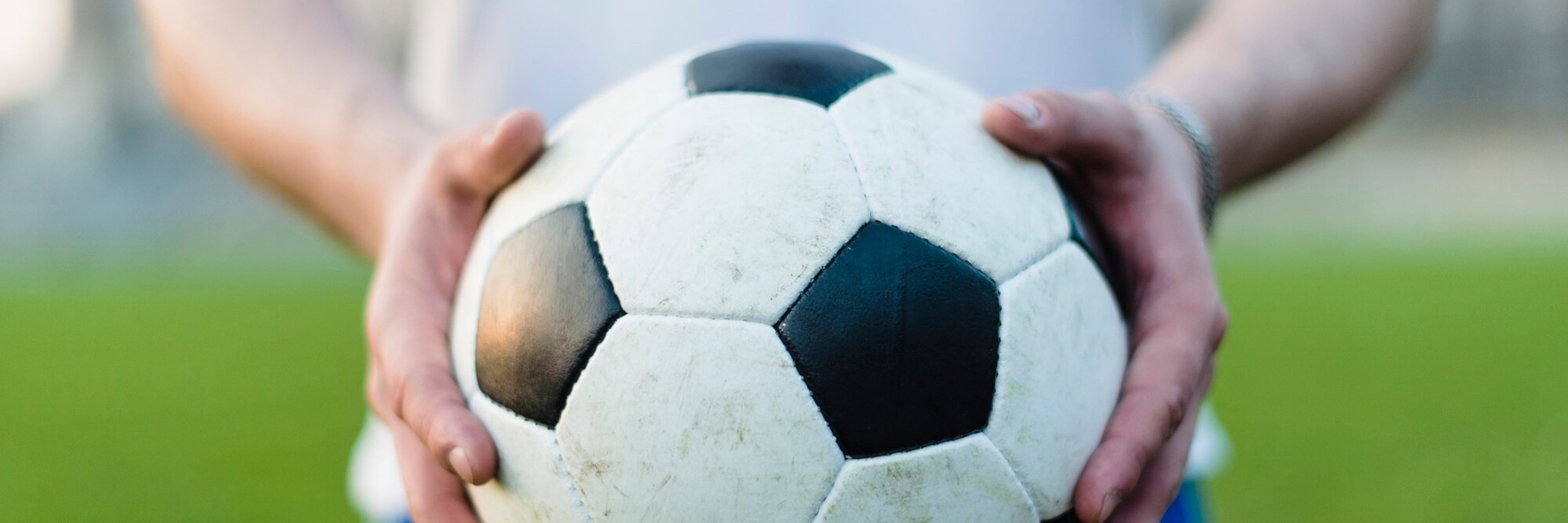 Fußball wird in der Hand gehalten