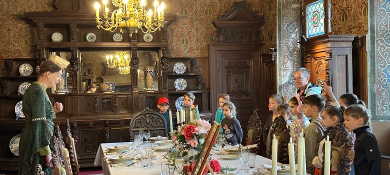 Klasse 1b steht mit Burgführerin im Rittersaal der Reichsburg Cochem