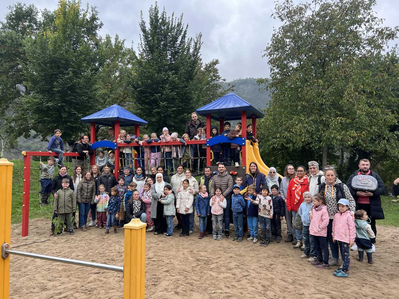 Klasse 1a und 1b machen ein Gruppenfoto vor dem Klettergerüst