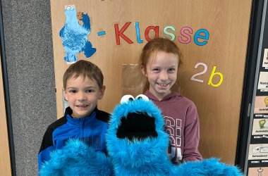 Klassensprecher der Klasse 2b Ein Junge und ein Mädchen halten das Krümelmonster in den Händen