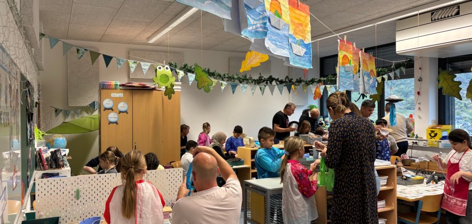 Kinder basteln mit ihren Eltern ihre Laterne