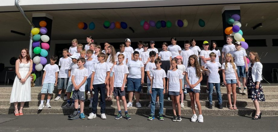 Alle Kinder stehen mit ihren Lehrerinnen auf der Treppe