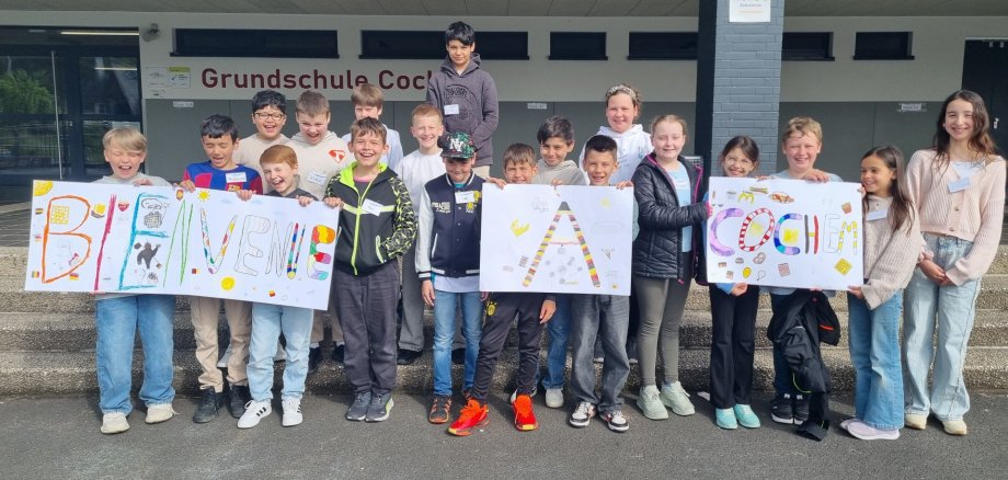 Willkommen Kinder mit einem Willkommensschild in der Hand